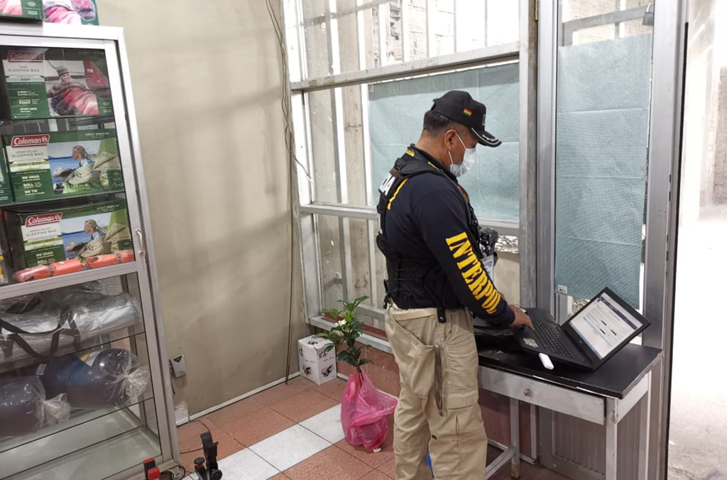 شرطي في لاباز يتحقق من أسلحة نارية معروضة للبيع في أحد المتاجر باستخدام قاعدة بيانات الإنتربول iARMS التي تتيح كشف أنماط الاتجار ومسالك التهريب.